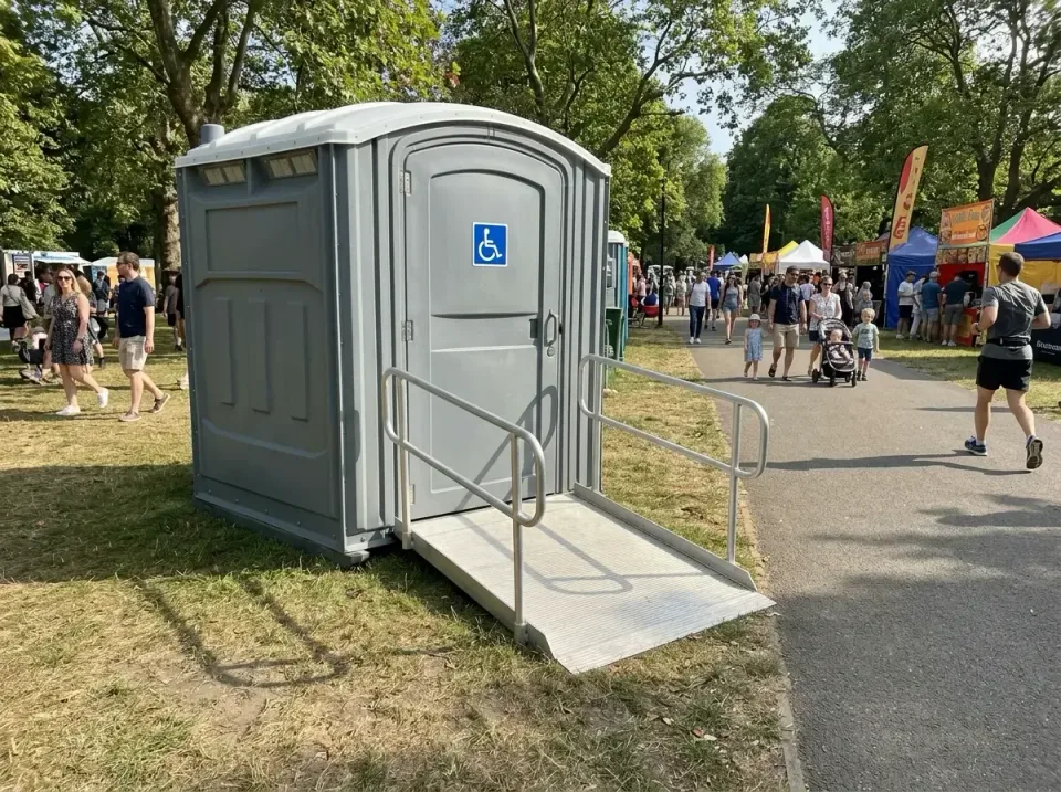 Wheelchair Accessible Porta Potty — Outdoor Event — Wheelchair Accessible Porta Potty, Access Ramp, Metal Handrails, Outdoor…